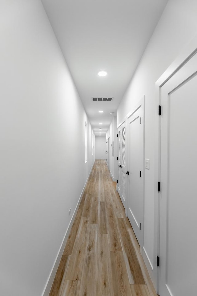 corridor with light hardwood / wood-style flooring