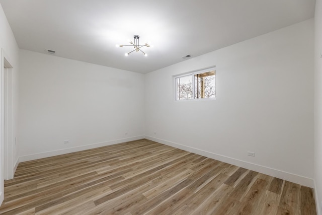 unfurnished room featuring light hardwood / wood-style flooring and a chandelier