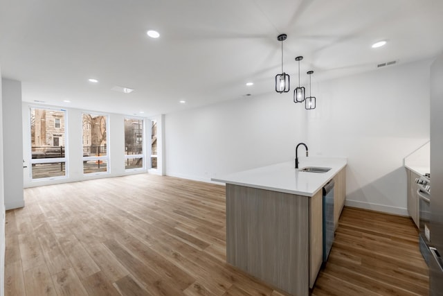 kitchen featuring dark hardwood / wood-style floors, decorative light fixtures, sink, kitchen peninsula, and stainless steel appliances