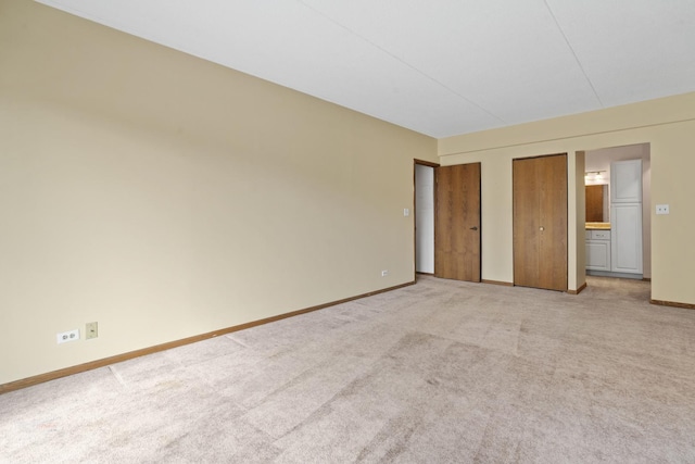 unfurnished bedroom with carpet flooring and two closets