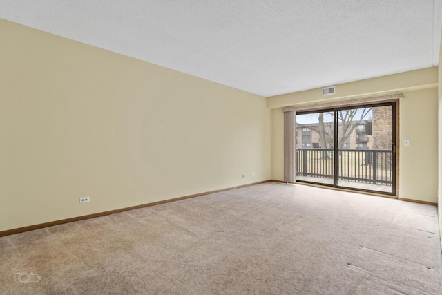 empty room featuring a textured ceiling and carpet