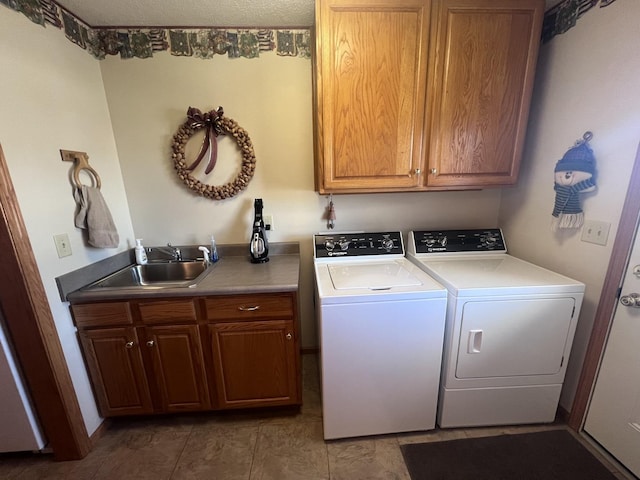 laundry area with independent washer and dryer, cabinets, and sink