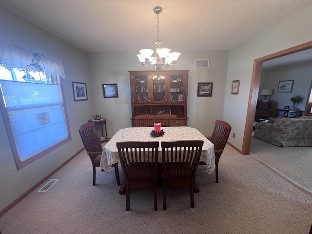 dining room featuring light carpet and an inviting chandelier