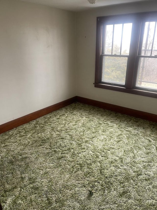 carpeted spare room featuring plenty of natural light