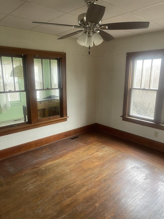 spare room featuring a drop ceiling, wood-type flooring, and ceiling fan