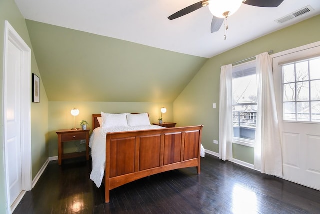 bedroom with dark hardwood / wood-style flooring, vaulted ceiling, and ceiling fan