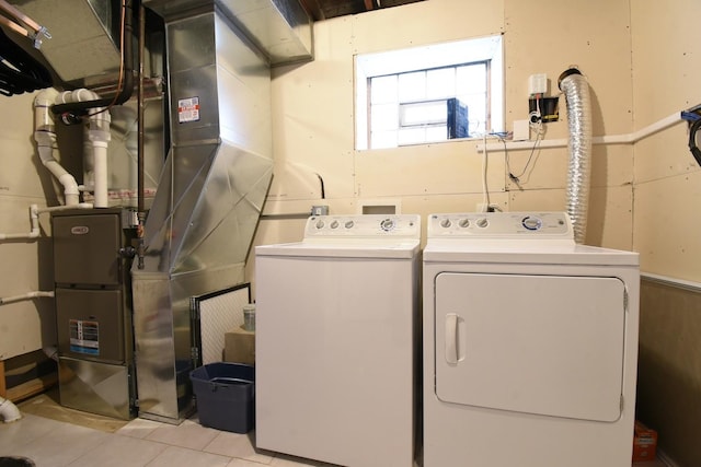 washroom with light tile patterned floors and washing machine and clothes dryer