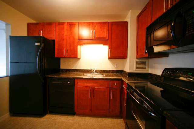 kitchen with sink, dark stone counters, and black appliances