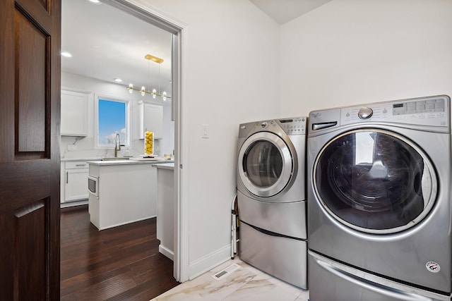 laundry area with recessed lighting, laundry area, separate washer and dryer, a sink, and baseboards