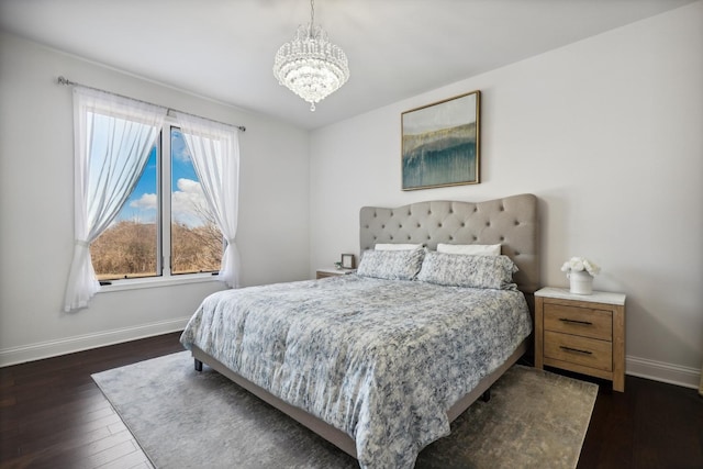 bedroom with dark wood-type flooring, a chandelier, and baseboards