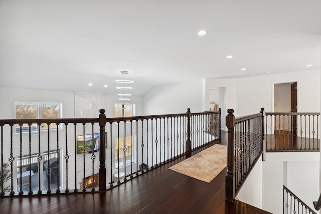 corridor with an inviting chandelier, wood finished floors, an upstairs landing, and recessed lighting