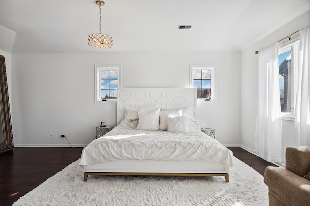 bedroom featuring dark wood-style flooring, visible vents, and baseboards