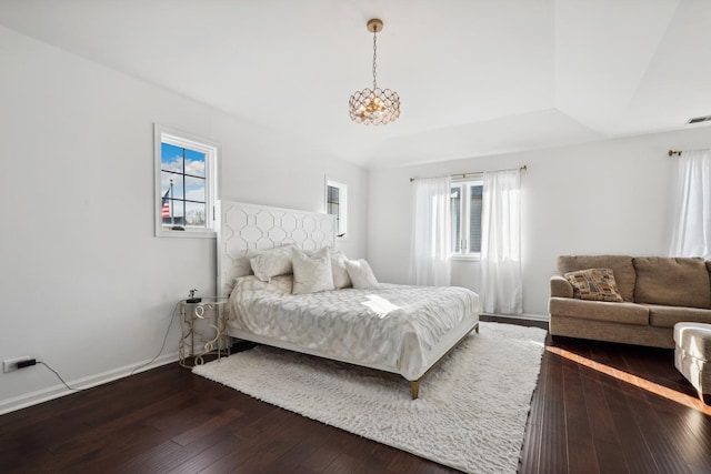 bedroom with dark wood-style floors, visible vents, and baseboards