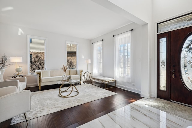 foyer with dark wood-type flooring, visible vents, and baseboards