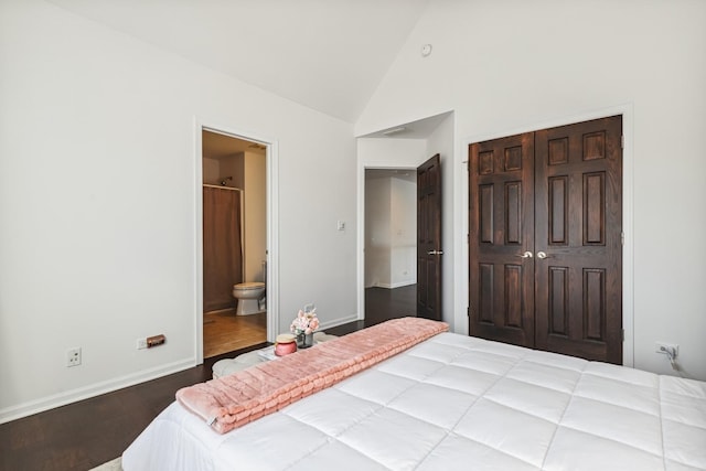 bedroom with a closet, connected bathroom, wood finished floors, high vaulted ceiling, and baseboards