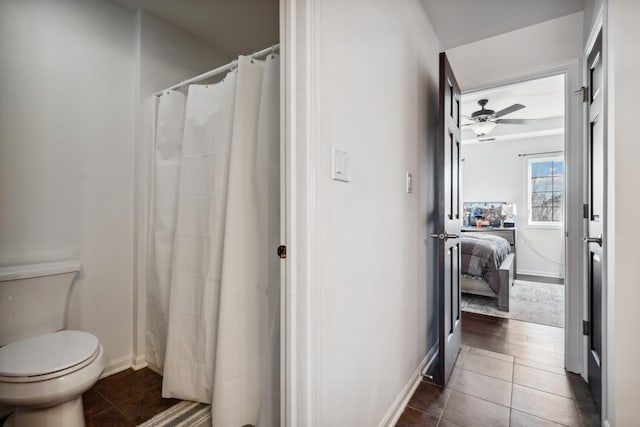 bathroom featuring baseboards, tile patterned flooring, toilet, and a ceiling fan