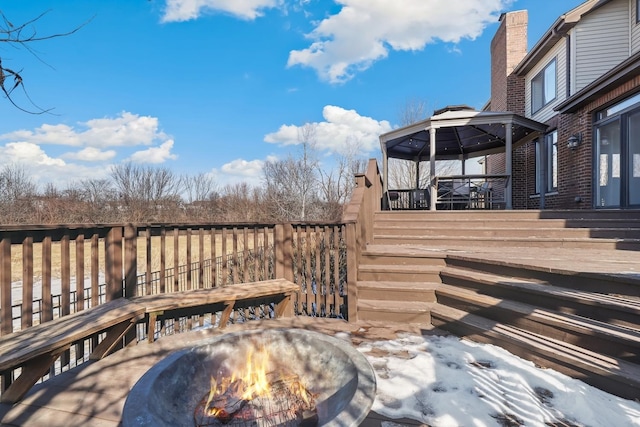 wooden terrace featuring an outdoor fire pit and a gazebo