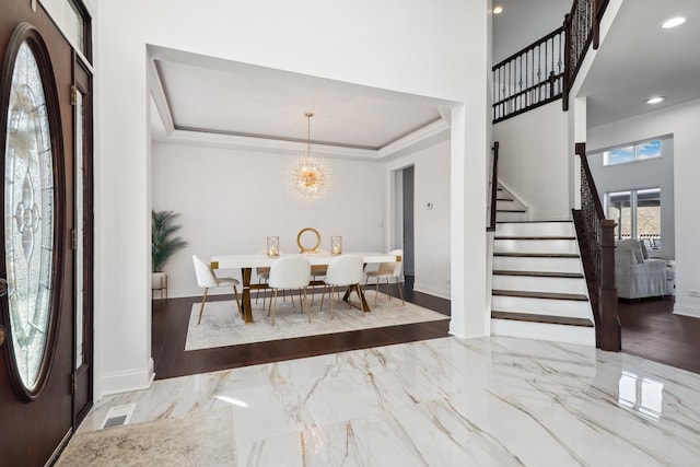 entryway featuring stairs, marble finish floor, ornamental molding, and a tray ceiling