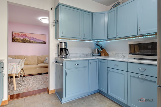 kitchen with blue cabinetry and light tile patterned floors