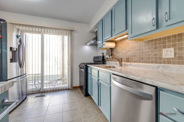 kitchen featuring blue cabinetry, sink, tasteful backsplash, appliances with stainless steel finishes, and a healthy amount of sunlight