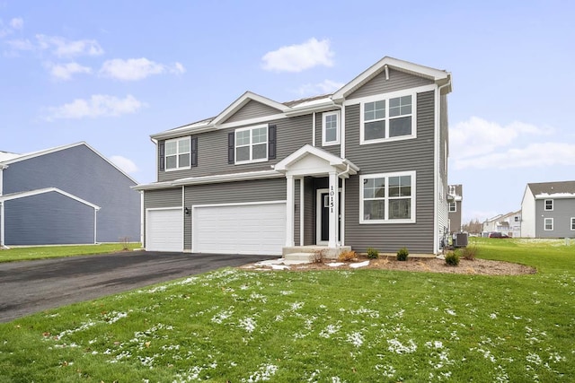 view of front of property with a garage, a front yard, and central AC unit