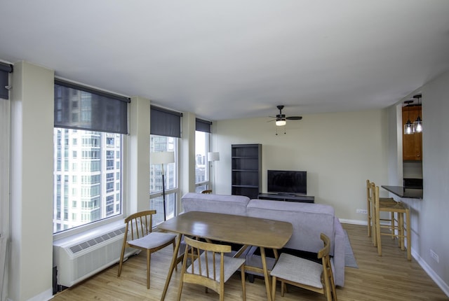 dining room featuring radiator, light hardwood / wood-style floors, and ceiling fan