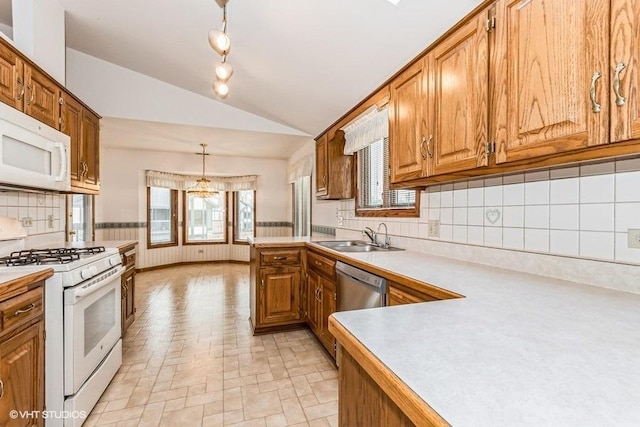 kitchen featuring light countertops, white appliances, a sink, and brown cabinets