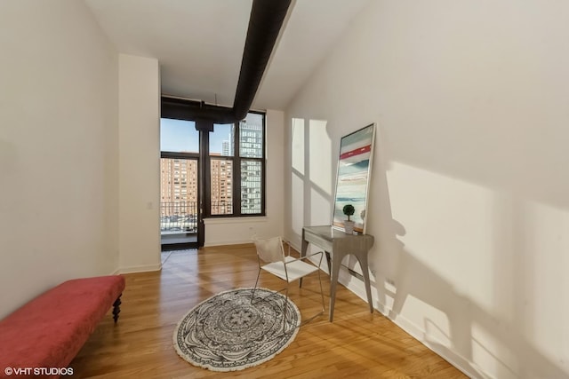 living area with hardwood / wood-style floors and beam ceiling