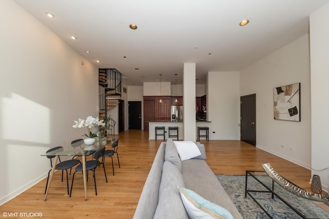 living room featuring light hardwood / wood-style flooring and a high ceiling