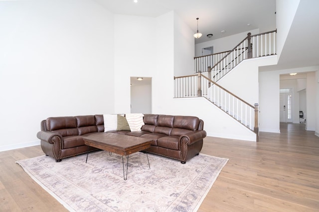 living room featuring a towering ceiling and light hardwood / wood-style flooring