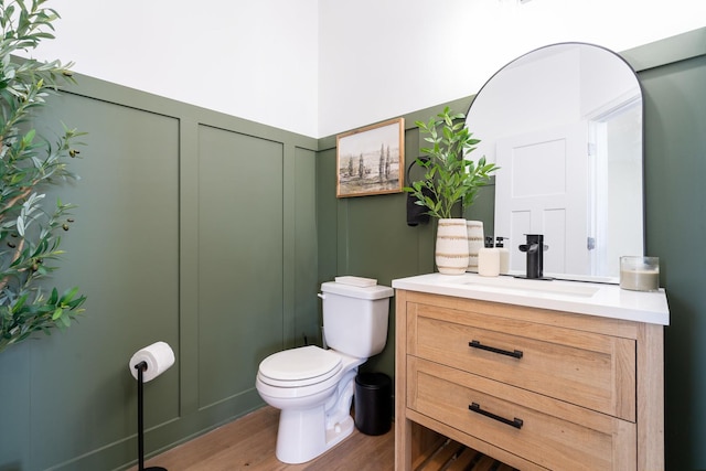 bathroom with vanity, toilet, and wood-type flooring