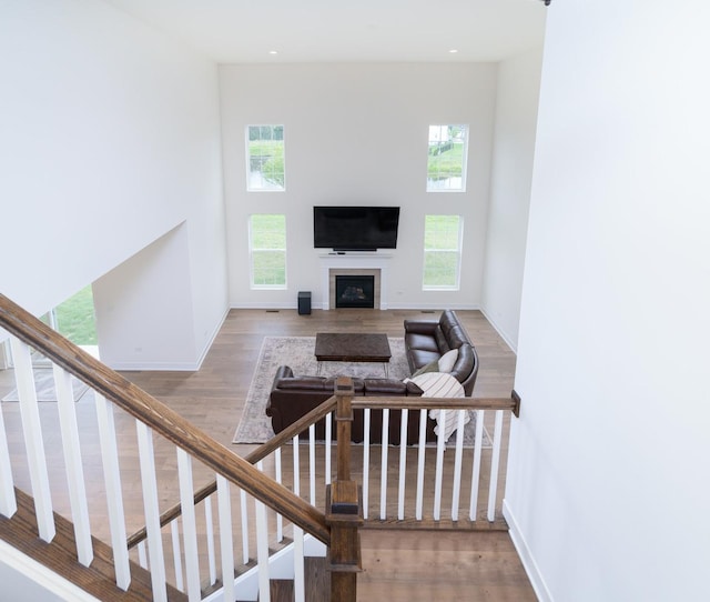 staircase with a towering ceiling and wood-type flooring