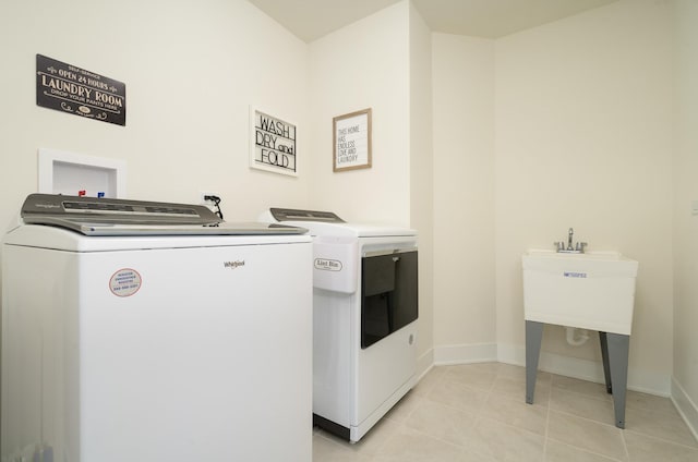 washroom with washer and clothes dryer and light tile patterned floors