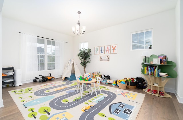 recreation room with an inviting chandelier and hardwood / wood-style floors