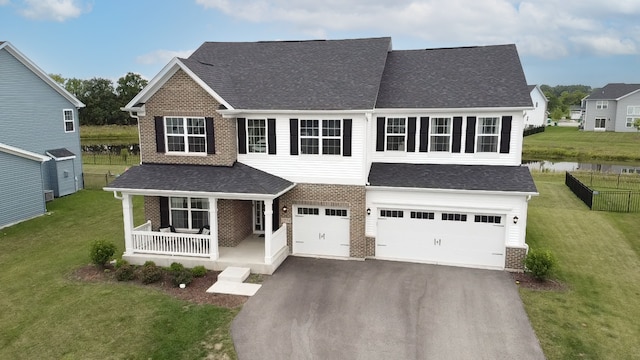 view of front facade featuring a garage, covered porch, and a front lawn