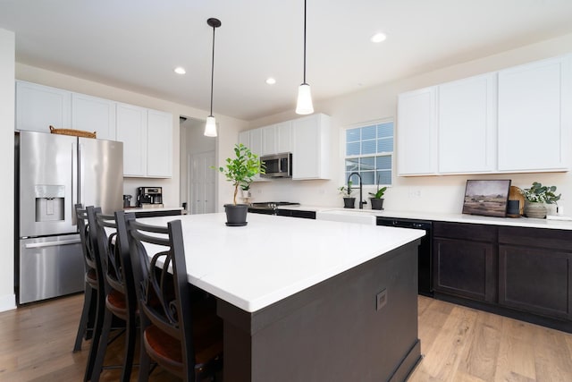 kitchen featuring a kitchen island, appliances with stainless steel finishes, sink, and white cabinets