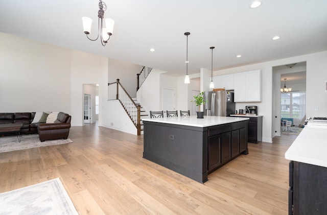 kitchen with an inviting chandelier, white cabinetry, hanging light fixtures, a center island, and stainless steel fridge with ice dispenser