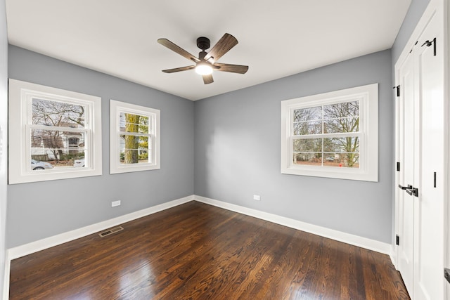 empty room with ceiling fan and dark hardwood / wood-style floors