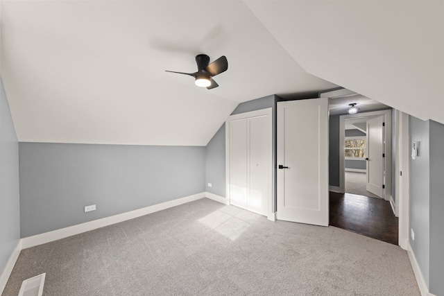 additional living space featuring light carpet, lofted ceiling, and ceiling fan