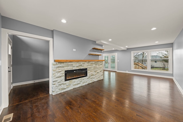 unfurnished living room featuring french doors, a fireplace, and dark hardwood / wood-style floors