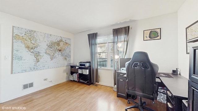 office with visible vents, baseboards, and wood finished floors