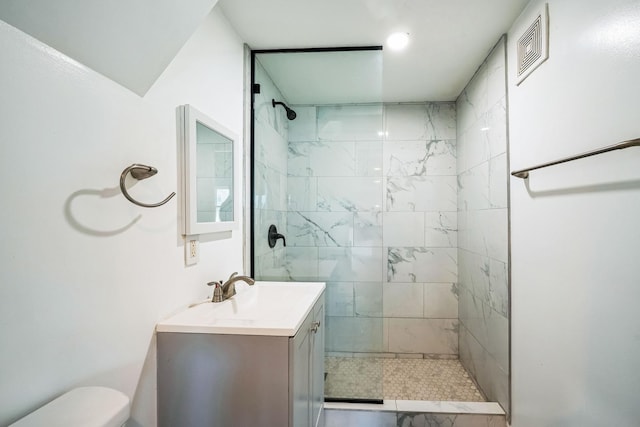 bathroom featuring vanity, toilet, and tiled shower