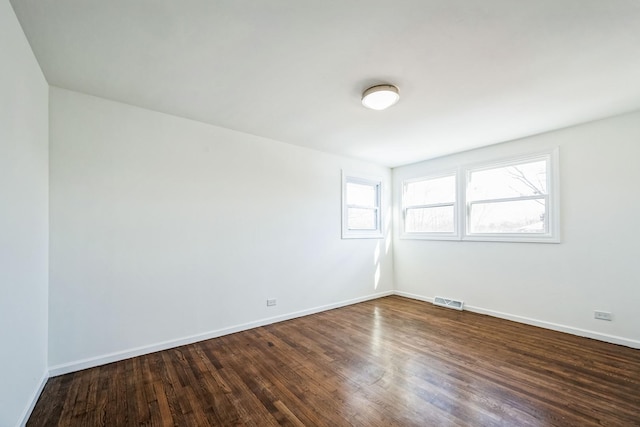 unfurnished room with dark hardwood / wood-style flooring