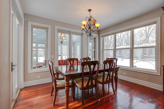 dining space featuring a notable chandelier, visible vents, baseboards, and wood finished floors