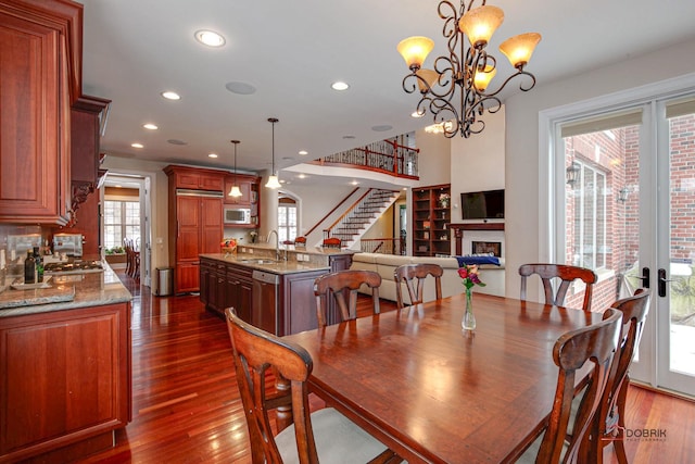 dining area with stairs, dark wood-type flooring, recessed lighting, and a fireplace