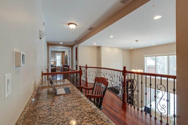 hallway featuring recessed lighting, visible vents, an upstairs landing, and wood finished floors