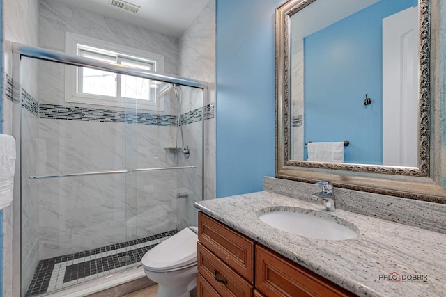 bathroom with visible vents, a stall shower, toilet, and vanity