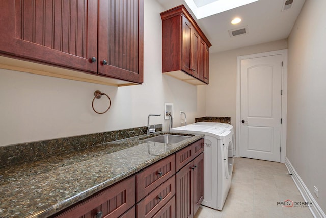 washroom with a sink, visible vents, cabinet space, and a skylight