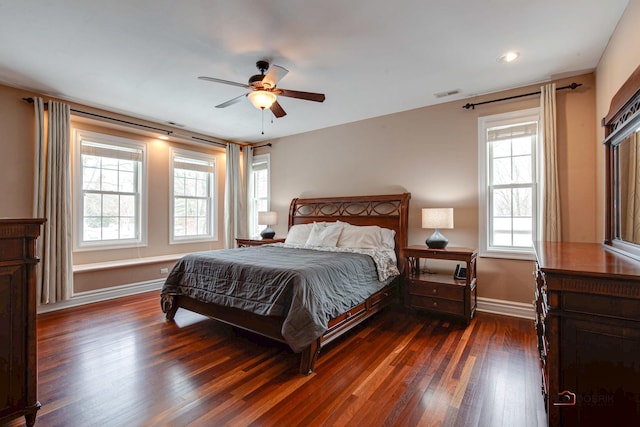 bedroom with visible vents, a ceiling fan, baseboards, and wood finished floors