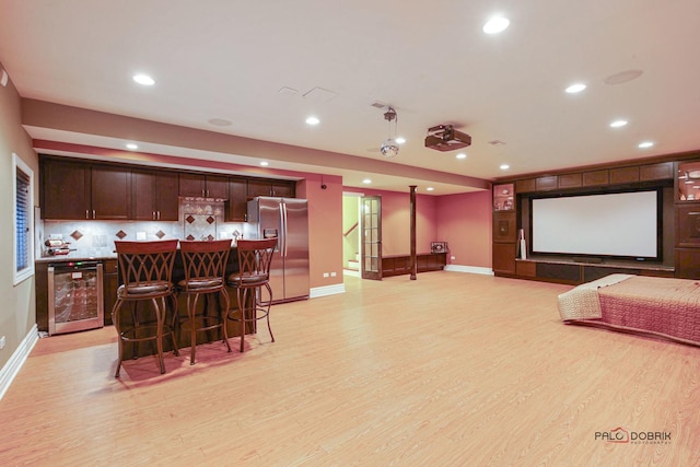 cinema room featuring wine cooler, recessed lighting, light wood-type flooring, and a dry bar